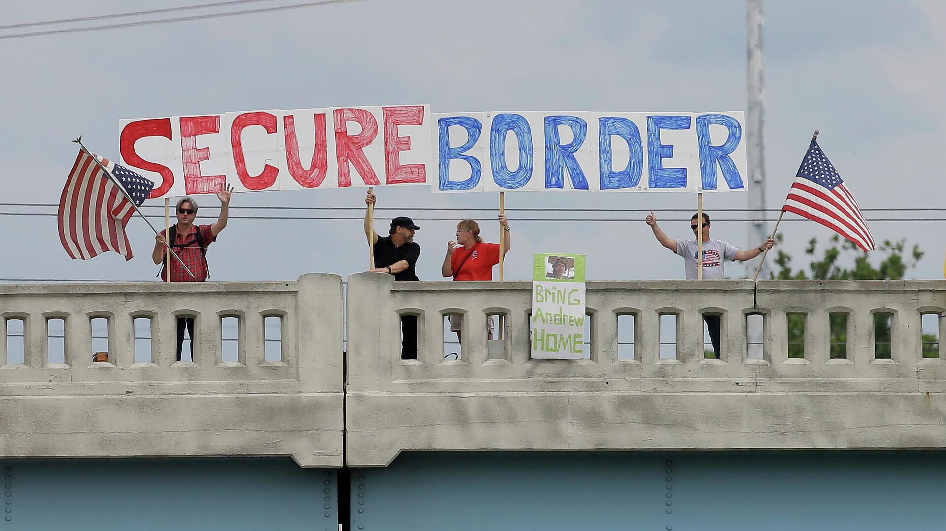 This July 18, 2014, file photo shows demonstrators with signs on an overpass in Indianapolis, to protest against people who immigrate illegally. Even as they grapple with an immigration crisis at the border, White House officials are making plans to act before November’s mid-term elections to grant work permits to potentially millions of immigrants in this country illegally, allowing them to stay in the United States without threat of deportation, according to advocates and lawmakers in touch with the administration. (AP Photo/Darron Cummings, File) - Sputnik International, 1920, 10.08.2022