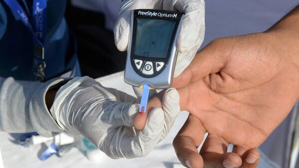 An Indian nurse (L) collects a blood sample from a policeman using a glucometer at a free diabetic health check-up camp on World Health Day in Hyderabad on April 7, 2016. - Sputnik International