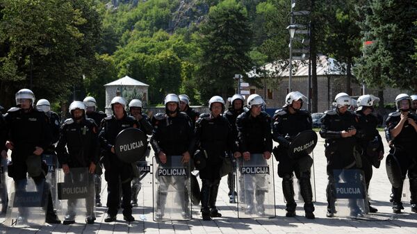 Police officers are seen in riot control gear while citizens of Montenegrin town of Cetinje gather at a baricade near the entrance of the city, on September 4, 2021, to protest against the enthronement of the new bishop of the Serbian Orthodox Church in Montenegro.  - Sputnik International
