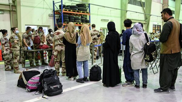 In this file photo taken on August 23, 2021 People wait to have their luggages checked by soldiers in a reunion and evacuation center at the French military air base 104 of Al Dhafra, near Abu Dhabi, after being evacuated from Kabul as part of the operation Apagan. - Sputnik International