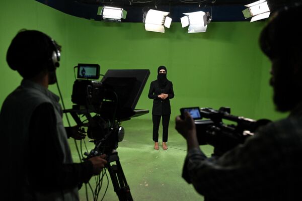In this photograph taken on 28 May 2022, a female Afghan presenter with Kabul-based news network 1TV, Lima Spesaly, delivers a live broadcast with her face entirely concealed by a veil. - Sputnik International