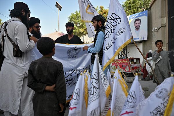 Men buy Taliban flags along a street in Kabul on 9 August 2022. - Sputnik International