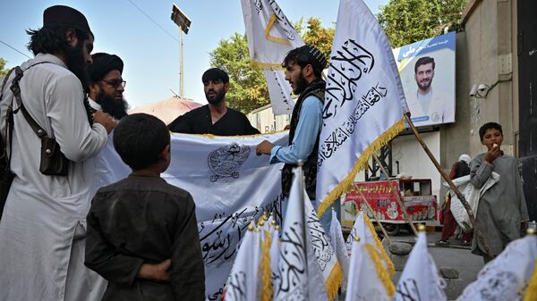 Men buy Taliban flags along a street in Kabul on August 9, 2022. - Sputnik International