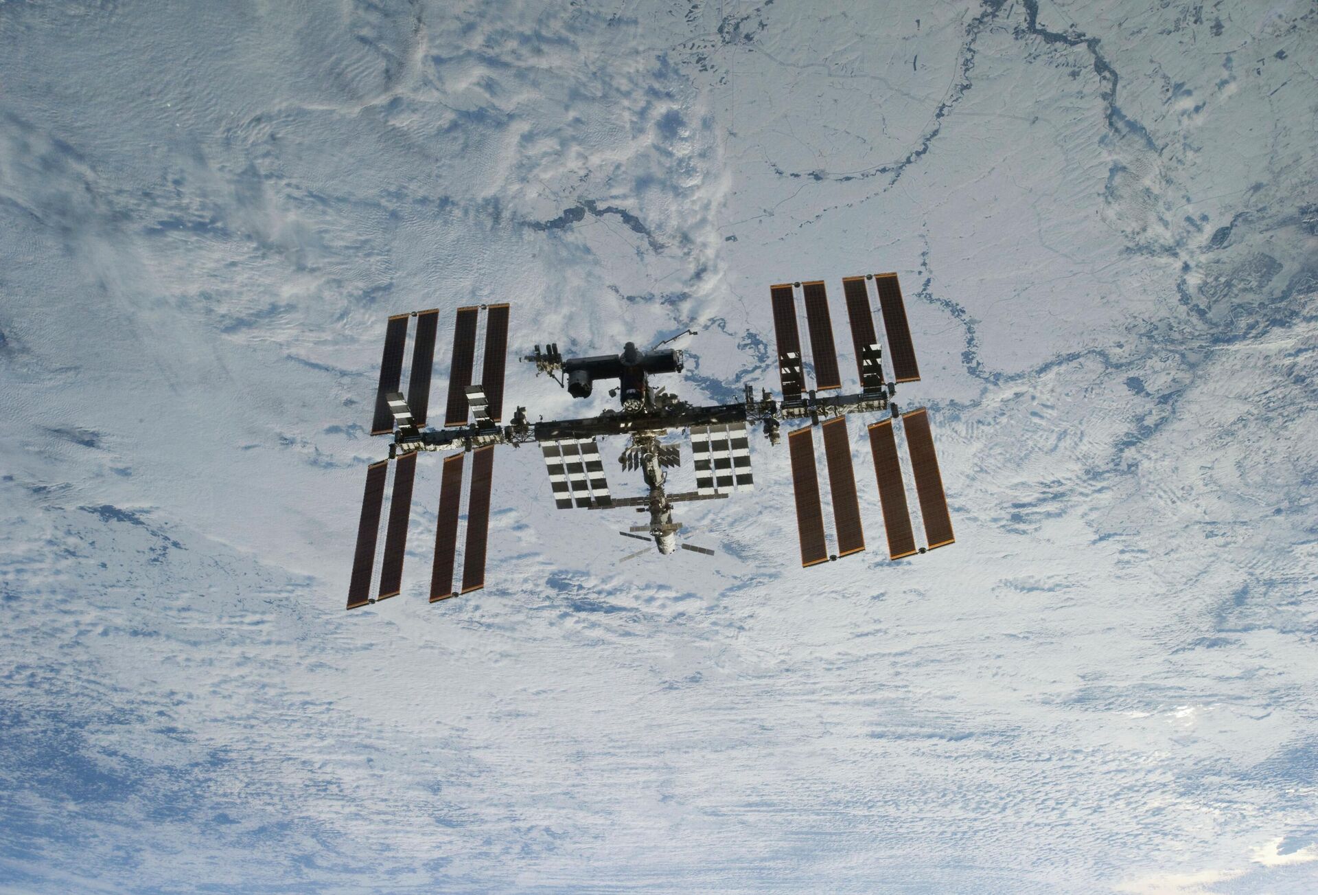  In this photo provided by NASA, backdropped against clouds over Earth, the International Space Station is seen from Space Shuttle Discovery as the two orbital spacecraft accomplish their relative separation on March 7, 2011 - Sputnik International, 1920, 06.03.2024