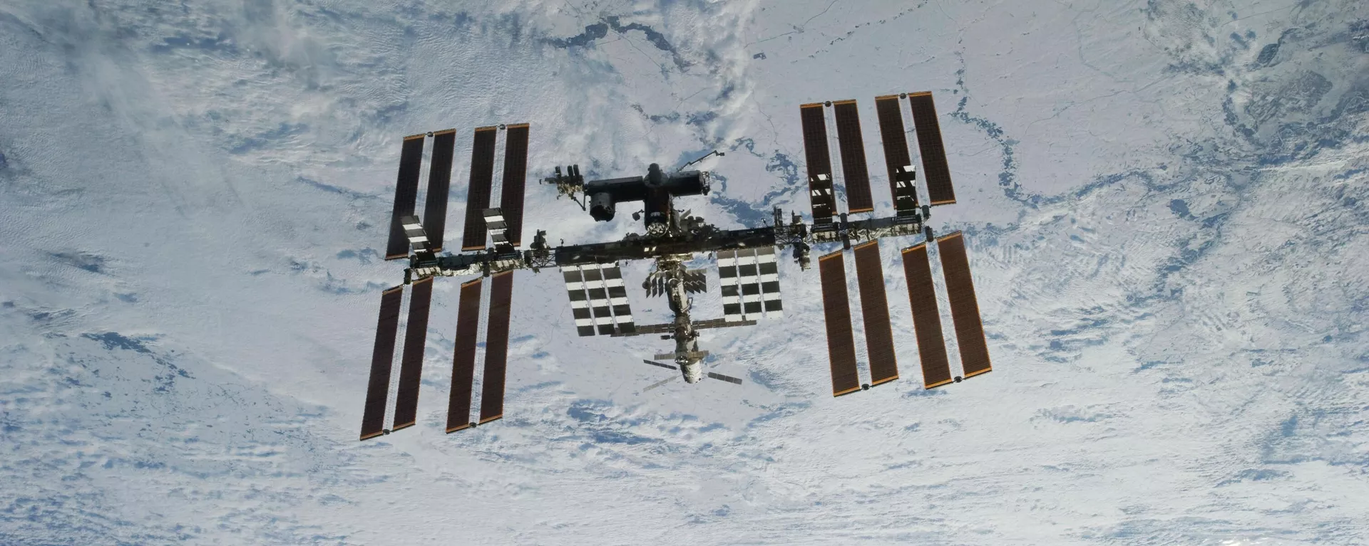  In this photo provided by NASA, backdropped against clouds over Earth, the International Space Station is seen from Space Shuttle Discovery as the two orbital spacecraft accomplish their relative separation on March 7, 2011 - Sputnik International, 1920, 06.09.2024