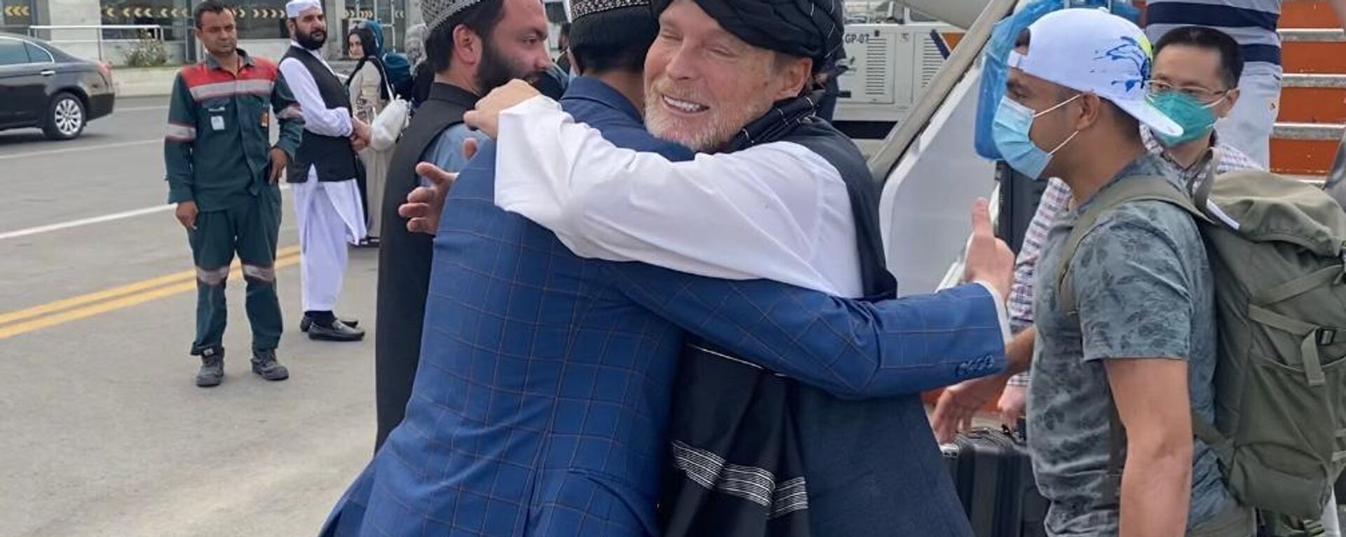 Former Taliban hostage Timothy Weeks hugging it out with a Taliban police spokesman upon his arrival back in Afghanistan to mark the one year anniversary of the fall of Kabul. - Sputnik International, 1920, 13.08.2022