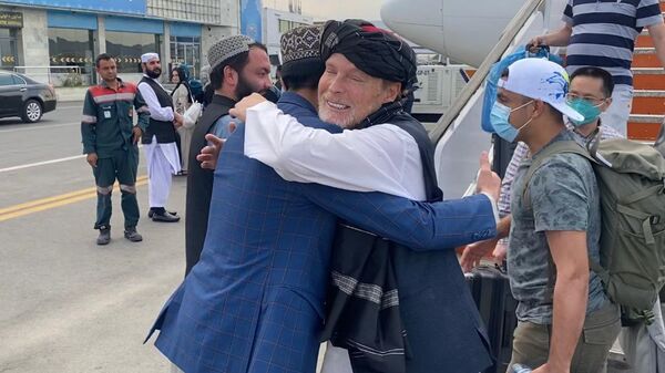 Former Taliban hostage Timothy Weeks hugging it out with a Taliban police spokesman upon his arrival back in Afghanistan to mark the one year anniversary of the fall of Kabul. - Sputnik International