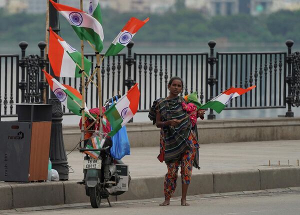 A roadside vendor carrying a child sells Indian flags on Independence Day in Hyderabad, India, Monday, Aug. 15, 2022. - Sputnik International