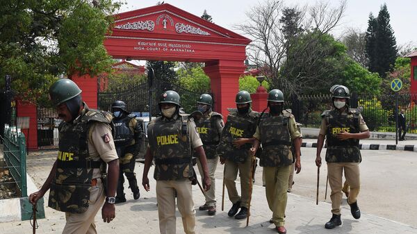 Police personnel stand in front of the Karnataka High Court in Bangalore on March 15, 2022, after the court upheld a local ban on the hijab in classrooms, weeks after the edict stoked violent protests and renewed fears of discrimination against the country's Muslim minority. - Sputnik International