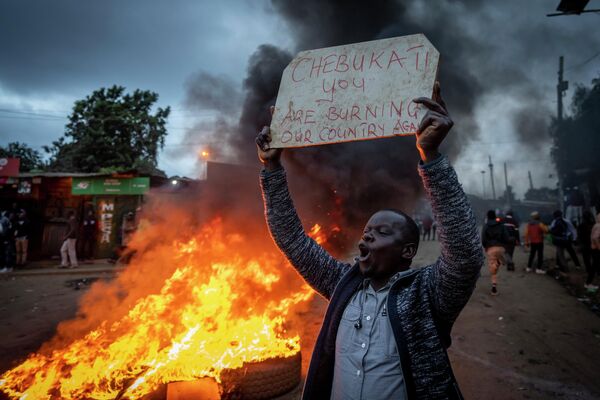 Сторонник кандидата в президенты Раилы Одинги рядом с блокпостом из горящих шин в районе Кибера в Найроби, Кения - Sputnik International