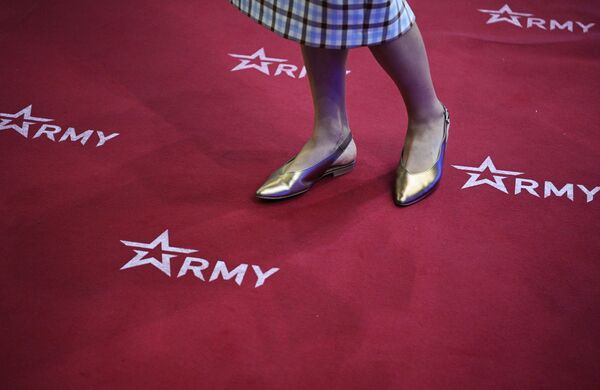 A girl stands on a carpet with the logo of the Army-2022 International Military-Technical Forum. - Sputnik International