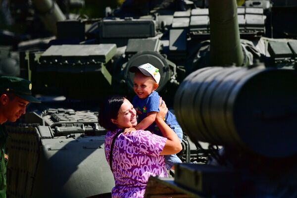 A woman with a child at the Army-2022 International Military-Technical Forum at the Patriot Congress and Exhibition Center. - Sputnik International