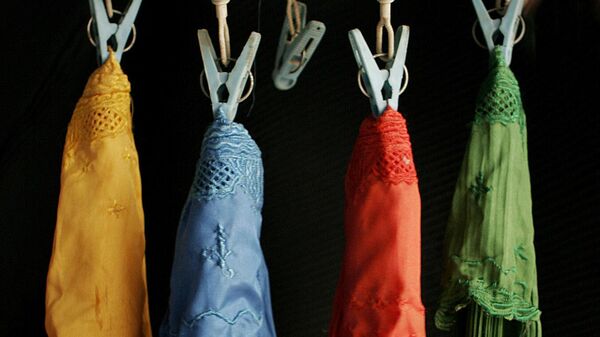 Small burqas in different colors hang in a burqa shop as decoration in Kabul, Afghanistan on April 30, 2007. - Sputnik International