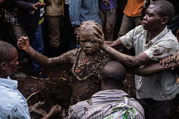 An initiate is smeared with mud during a traditional circumcision, called Imbalu in Mutoto, on August 13, 2022.  Imbalu is a biannual rite of passage of the Bagisu ethnic community in eastern Uganda, the transition of boys into adult men.  - Sputnik International