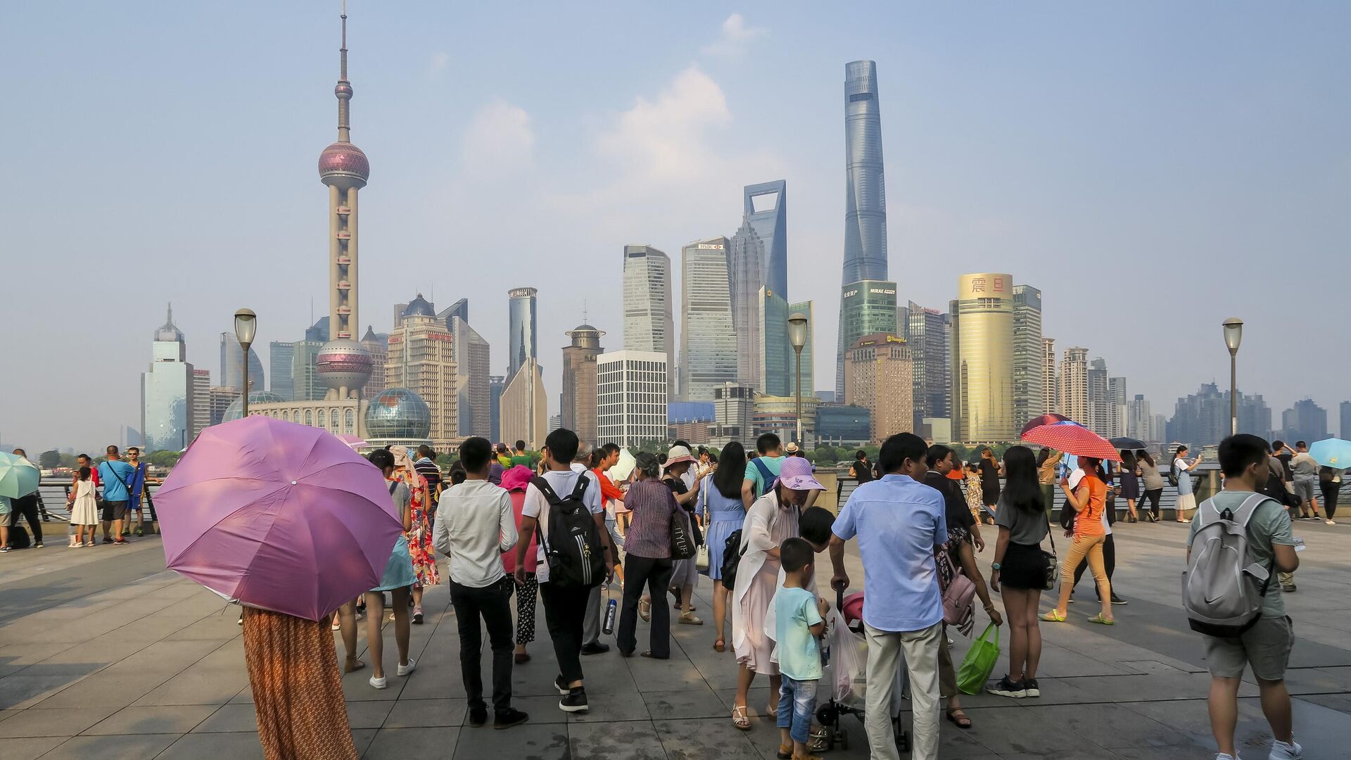 People walk on the waterfront bund in Shanghai on July 21, 2017. - Shanghai sweltered under a new record high of 40.9 degrees Centigrade (105 F) on July 21, authorities said as they issued a weather red alert over a stubborn heat wave that has plagued much of the country. - Sputnik International, 1920, 20.08.2022