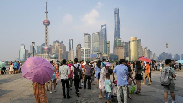 People walk on the waterfront bund in Shanghai on July 21, 2017. - Shanghai sweltered under a new record high of 40.9 degrees Centigrade (105 F) on July 21, authorities said as they issued a weather red alert over a stubborn heat wave that has plagued much of the country. - Sputnik International