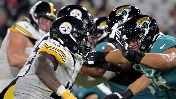 The Pittsburgh Steelers, left. go against the against the Jacksonville Jaguars during the second half of an NFL preseason football game, Saturday, Aug. 20, 2022, in Jacksonville, Fla. - Sputnik International