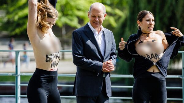 Demonstrators take their shirts off to protest topless with the slogan reading GAS EMBARGO NOW on their skin, beside German Chancellor Olaf Scholz during the Federal Government's Open Day event at the Chancellery in Berlin on August 22, 2022. - Sputnik International