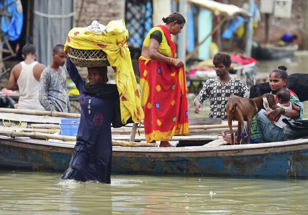 Flood-affected residents of a low-lying area on the banks of the River Ganges move their belongings to drier ground at Daraganj area in Allahabad on 19 August 2022, after water levels rose following monsoon rains. - Sputnik International