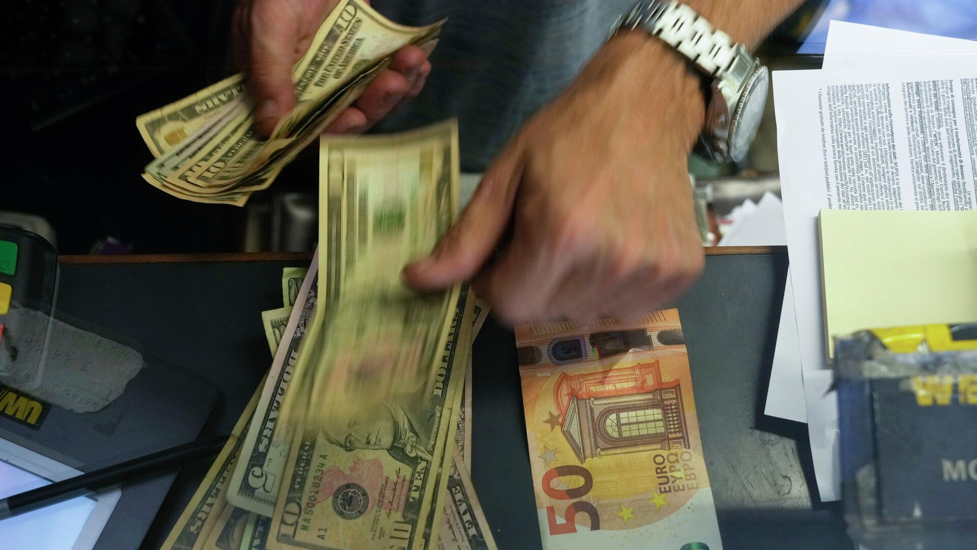 A cashier changes a 50 Euro banknote with US dollars. - Sputnik International, 1920, 08.03.2023