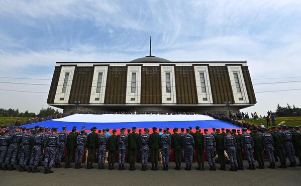Russian servicemen hold a huge Russian tricolor outside the Victory Museum in Moscow, August 22, 2022.  - Sputnik International