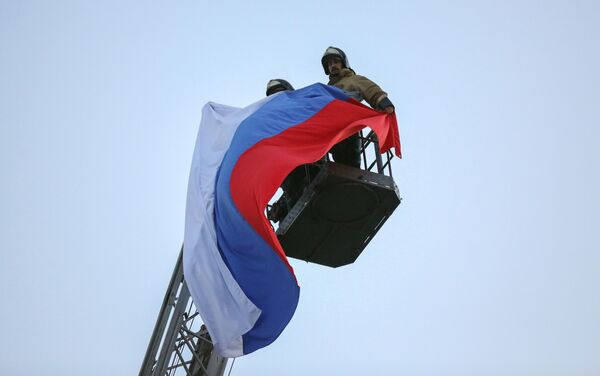 Rescue workers from the Russian Emergency Situations Ministry raising the Russian tricolor in central Donetsk, DPR. - Sputnik International