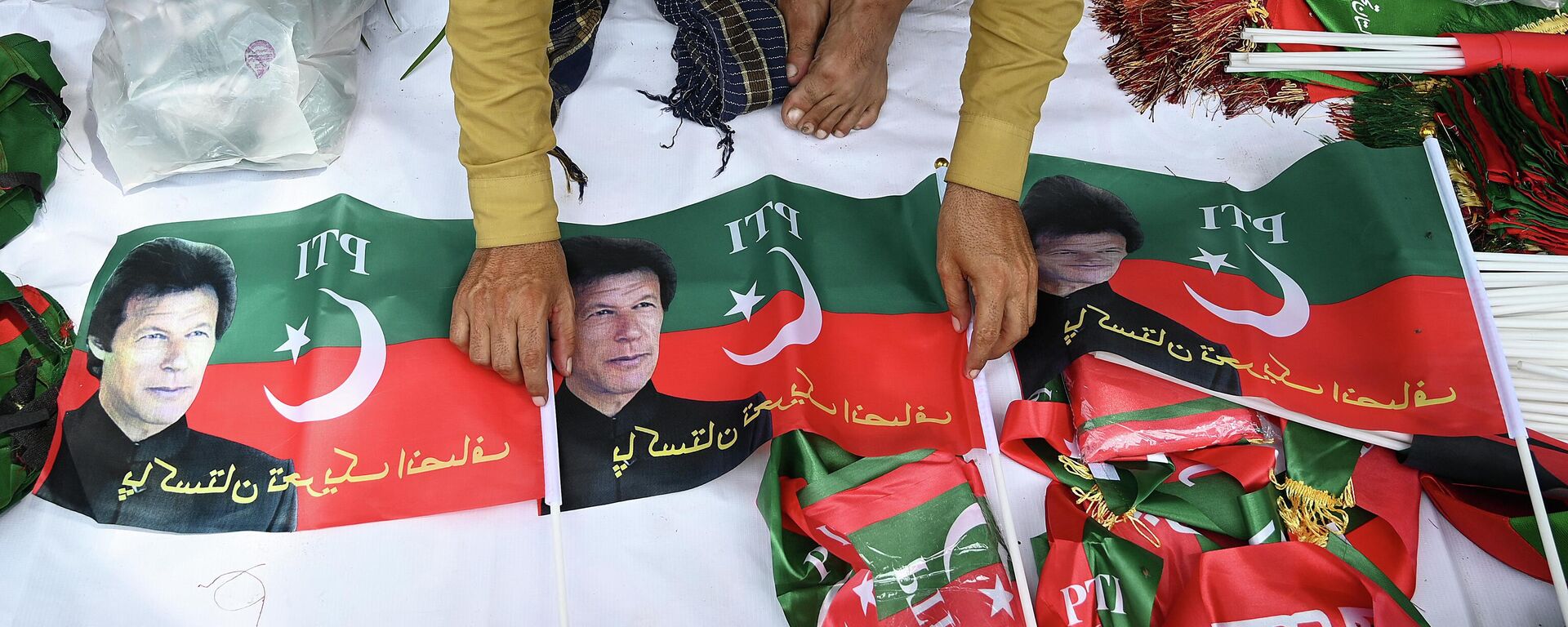 A vendor sells flags of Pakistan Tehreek-e-Insaf (PTI) party portraying Pakistan's former prime minister Imran Khan, outside the Khan's residence in Islamabad on August 22, 2022. - Sputnik International, 1920, 22.08.2022