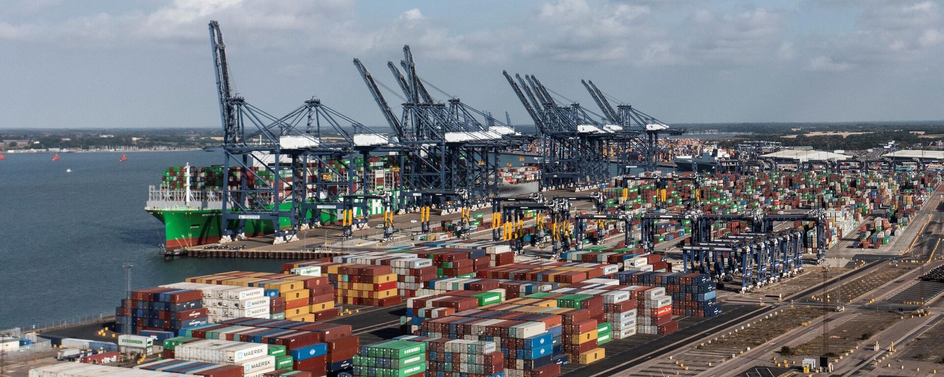 An aerial photograph taken on August 22, 2022 shows the Ever Alot container ship docked by stopped container loading cranes at the empty UK's largest freight port, in Felixstowe, during a dock workers eight-day strike over pay. - Sputnik International, 1920, 22.08.2022