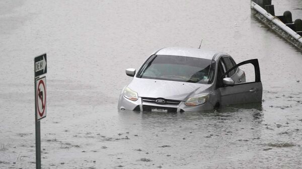 A car sits in flood waters covering a closed highway in Dallas, Monday, Aug. 22, 2022. - Sputnik International