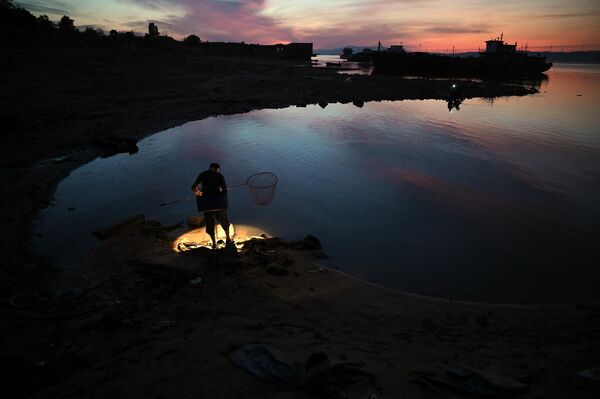 A fisherman stands on the banks of Lake Poyang in Juijiang, China&#x27;s central Jiangxi province - Sputnik International