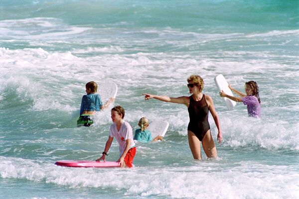 In this file photo taken on January 1, 1993 Diana, The Princess of Wales (2nd R) heads out into the surf as her sons William and Harry enjoy the waters of Indian Castle Beach during a vacation on Nevis. - Twenty-five years on from the death of their mother, princess Diana, Prince William and Prince Harry are struggling to maintain their formerly close relationship. - Sputnik International