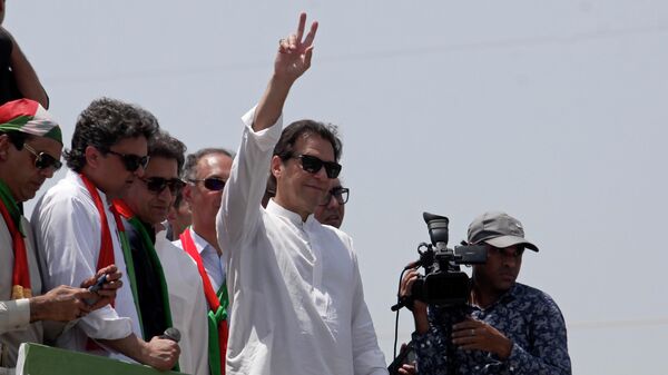 Ousted Pakistani Prime Minister Imran Khan gives the victory sign to supporters as he leads a march toward Islamabad, in Swabi, Pakistan, Wednesday, May 25, 2022. - Sputnik International