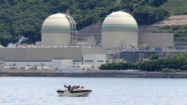 A boat of the Japan Coast Guard patrols in front of the No. 3 reactor (L) at the Takahama nuclear plant in Takahama, Fukui prefecture, some 350 kilometres (215 miles) west of Tokyo on June 6, 2017 - Sputnik International