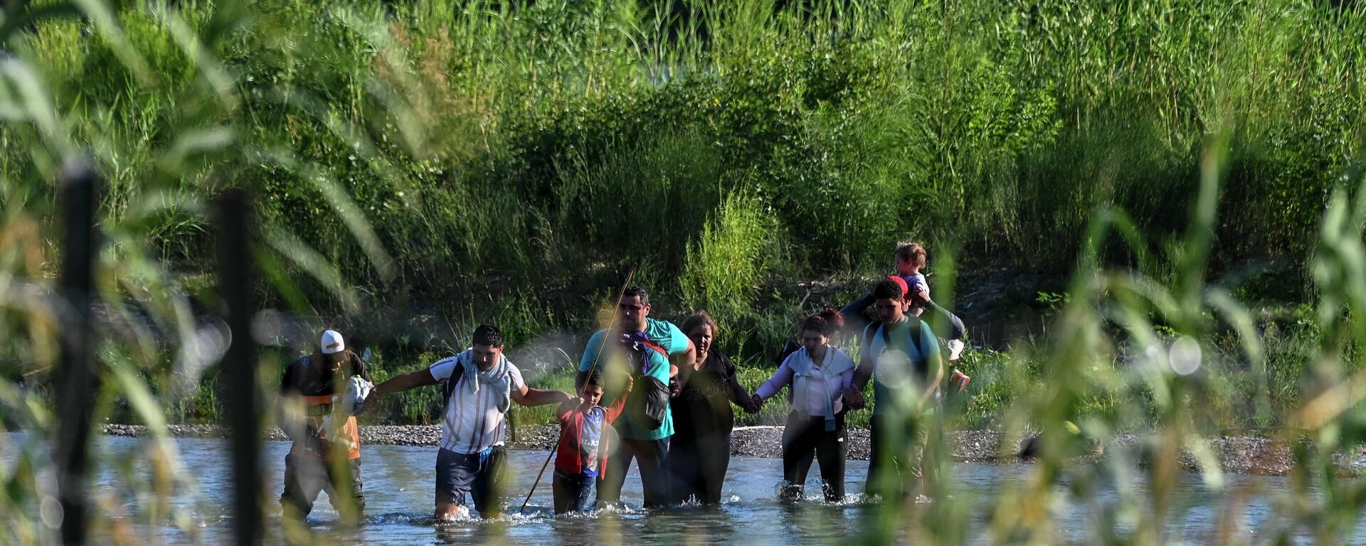 A migrant family from Venezuela illegally crosses the Rio Grande River in Eagle Pass, Texas, at the border with Mexico on June 30, 2022.  - Sputnik International, 1920, 04.09.2022
