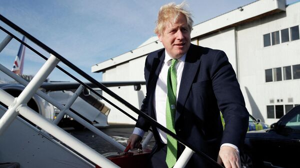 Britain's Prime Minister Boris Johnson carries his ministerial briefcase as he boards an aircraft in London, on February 1, 2022, before departing for Kyiv, to meet with Ukraine's President Volodymyr Zelenskiy - Sputnik International