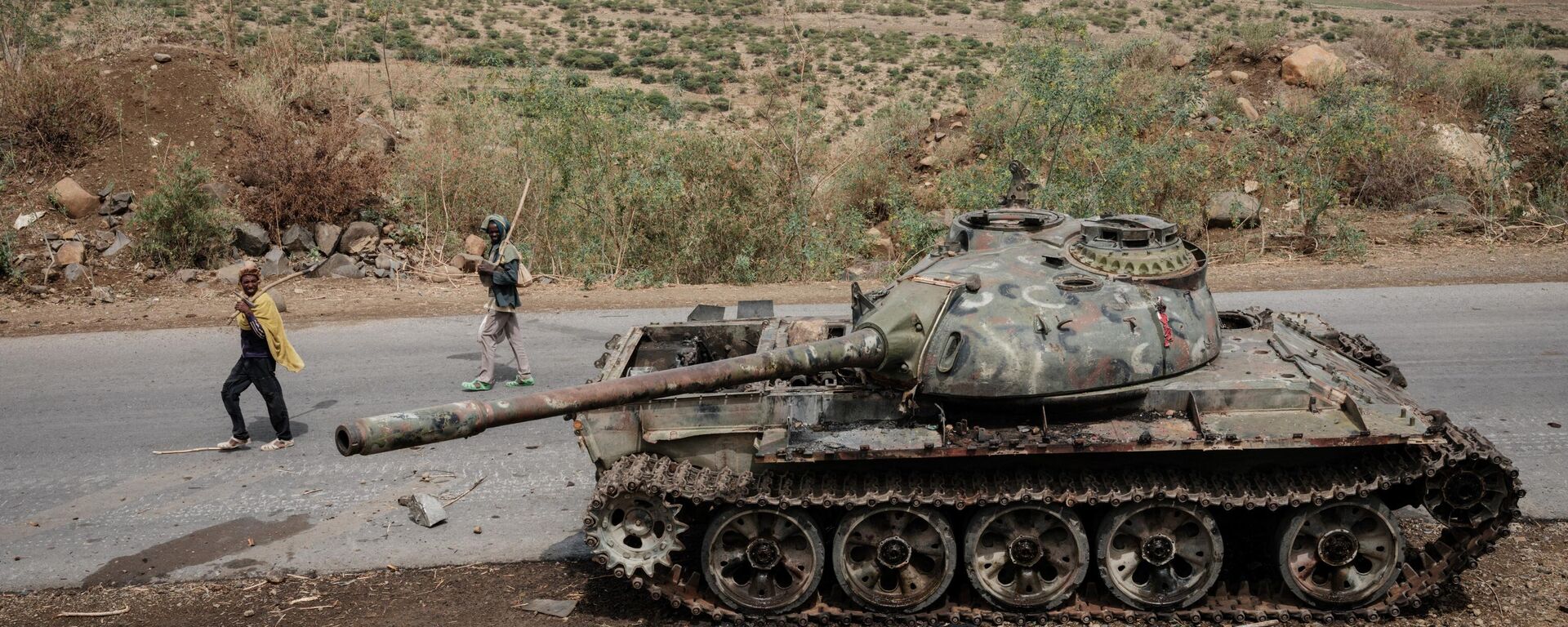 In this file photo taken on June 20, 2021 Local farmers walk next to a tank of alledged Eritrean army that is abandoned along the road in Dansa, southwest of Mekele in Tigray region, Ethiopia. - Sputnik International, 1920, 24.08.2022
