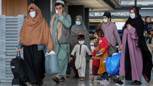 Families evacuated from Kabul, Afghanistan walk through the terminal to board a bus after they arrived at Washington Dulles International Airport, in Chantilly, Va., Sept. 1, 2021. - Sputnik International