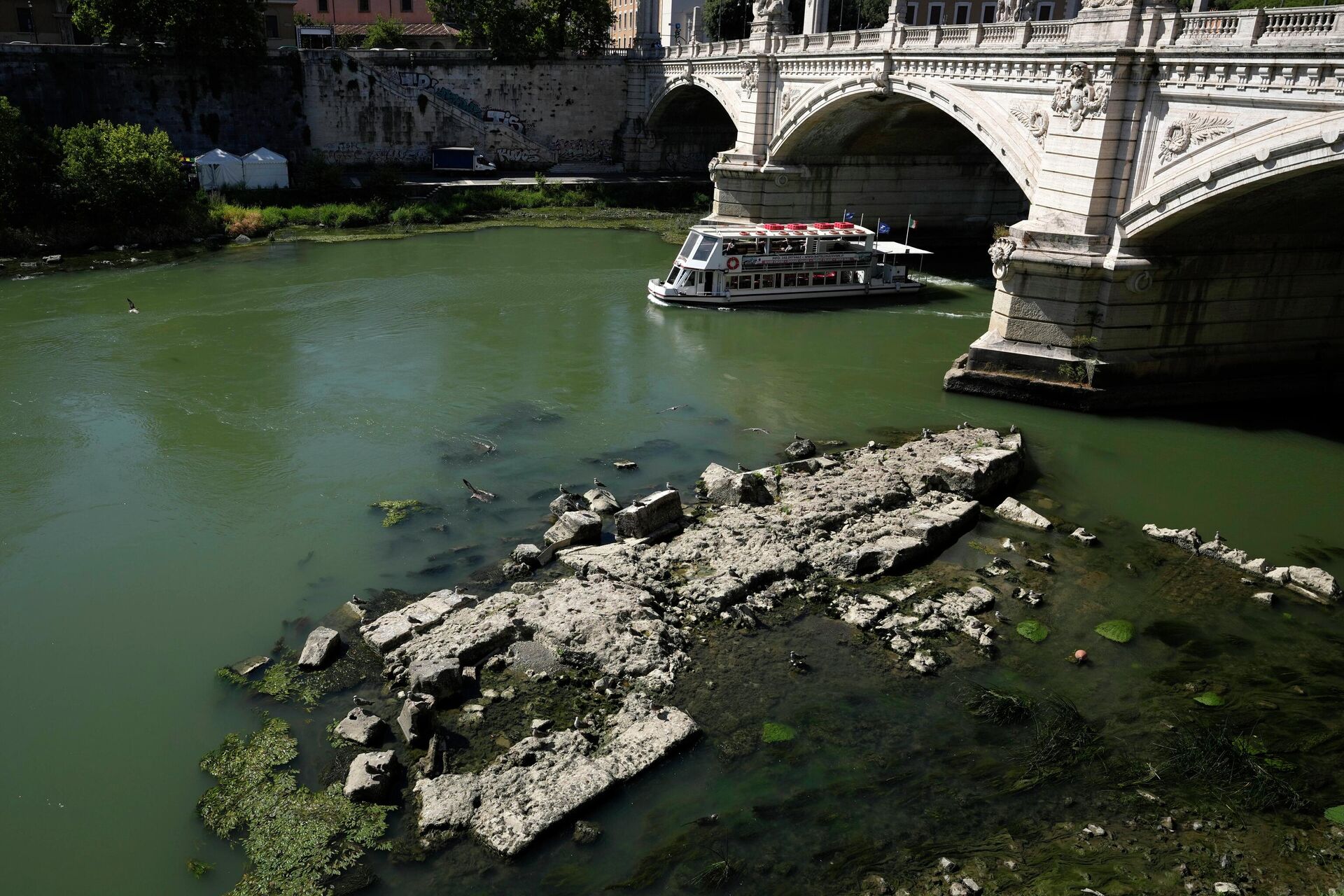 A boat passes by the ruins of the ancient Roman Neronian bridge, usually submerged by the Tiber, in Rome, Thursday, June 30, 2022 - Sputnik International, 1920, 25.08.2022