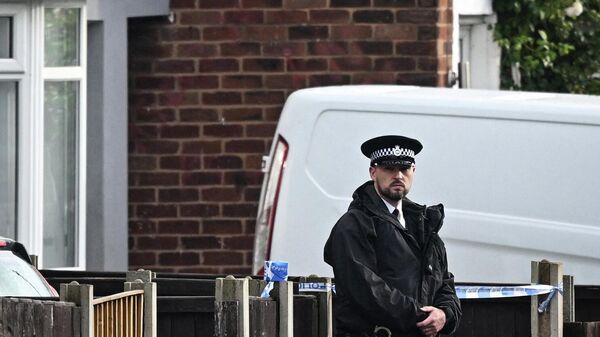 A police officer stands guard in front of a house in the Knotty Ash area in Liverpool where a nine-year-old girl was fatally shot - Sputnik International