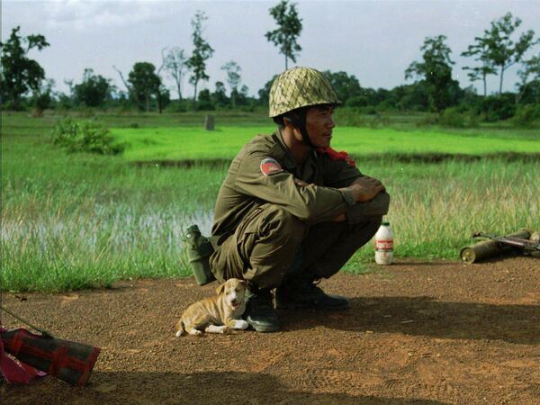 A government soldier befriends a stray puppy before heading into battle against resistance fighters loyal to Cambodia&#x27;s ousted co-premier Prince Norodom Ranariddh Saturday, Aug. 9, 1997 near Khtum, close to Cambodian northern border with Thailand.  - Sputnik International