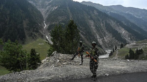 Indian paramilitary troopers stand guard near the entrance of the Zojila tunnel under construction which connects Srinagar to the union territory of Ladakh, at Baltal, some 93 km northeast of Srinagar, on September 28, 2021. - Sputnik International
