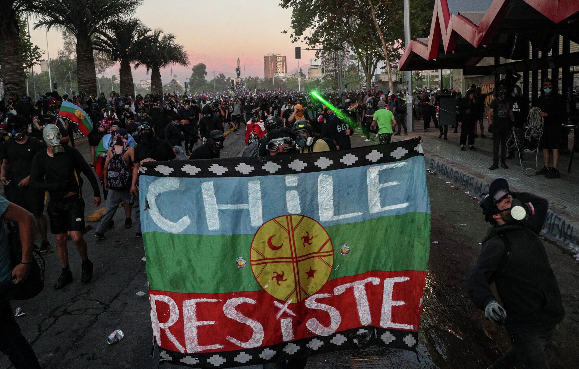 An anti-government protester holds a Mapuche flag during a demonstration against police after an officer was accused of allegedly pushing a youth off a bridge during a previous protest in Santiago, Chile, Friday, Oct. 9, 2020. - Sputnik International, 1920, 29.08.2022