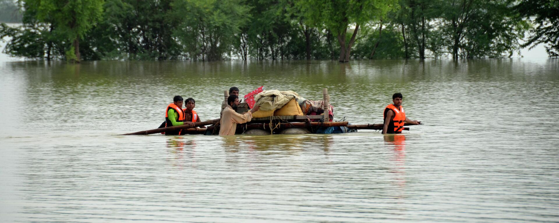 Displaced people transport usable belongings salvaged from their flood-hit home as they cross a flooded area in Sohbat Pur city of Jaffarabad, a district of Pakistan's southwestern Baluchistan province, Sunday, Aug. 28, 2022. - Sputnik International, 1920, 29.08.2022