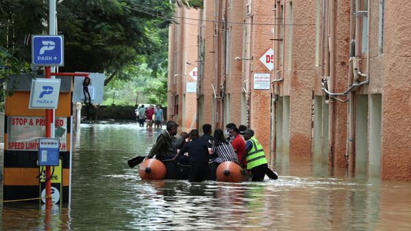Rescue workers move stranded residents of an apartment in a boat after it was flooded due to heavy rains in Bengaluru, India, Monday, Nov. 22, 2021. - Sputnik International