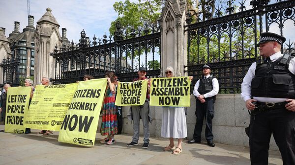 Extinction Rebellion activists hold banners outside of Britain's Houses of Parliament - Sputnik International