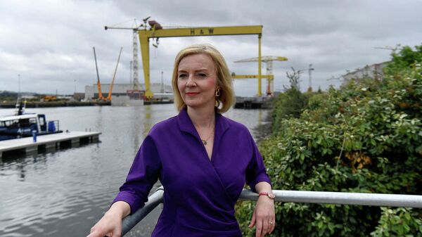 In this file photo taken on August 17, 2022 Contender to become the country's next Prime minister and leader of the Conservative party British Foreign Secretary Liz Truss (C) poses for a photograph with the Harland and Wolff shipyard cranes at a Conservative Party leadership campaign event, at Artemis Technologies in Belfast Harbour, Belfast - Sputnik International