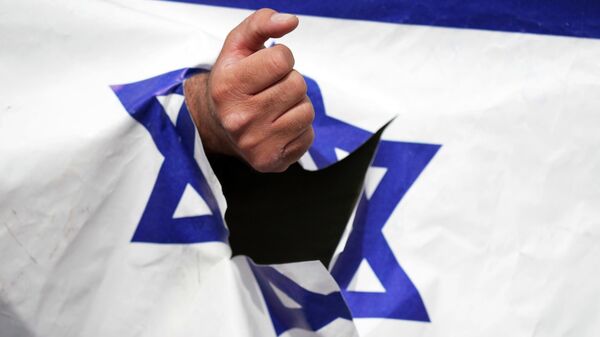 A demonstrator clenches his fist through a torn up representation of the Israeli flag in the annual pro-Palestinian Al-Quds, or Jerusalem, Day rally in Tehran, Iran, Friday, April 29, 2022 - Sputnik International