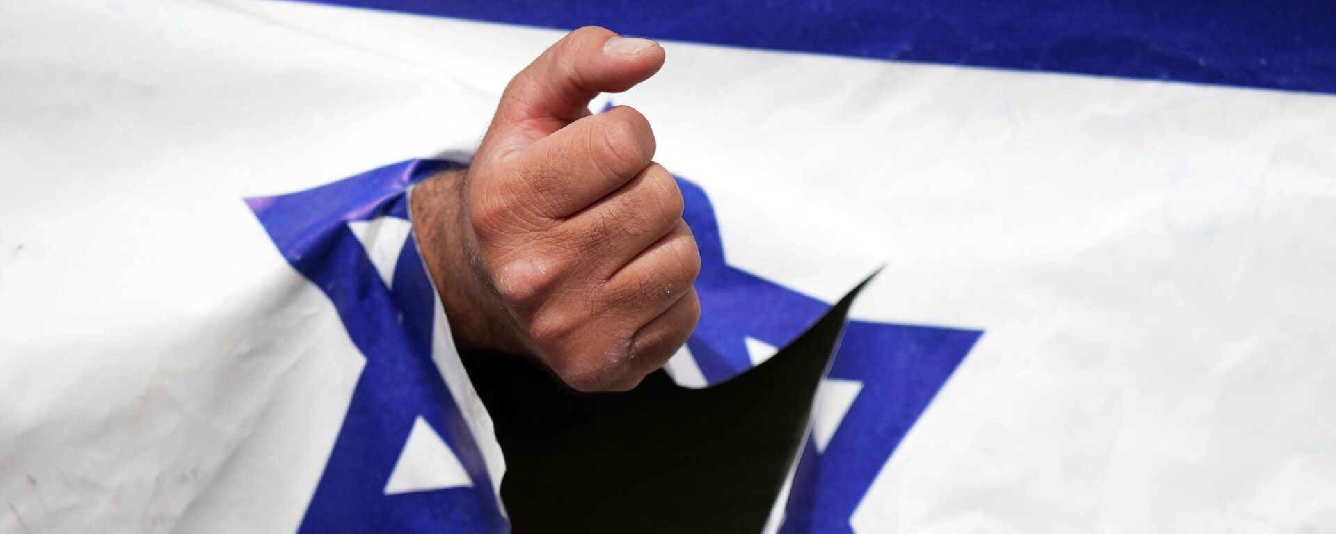 A demonstrator clenches his fist through a torn up representation of the Israeli flag in the annual pro-Palestinian Al-Quds, or Jerusalem, Day rally in Tehran, Iran, Friday, April 29, 2022 - Sputnik International, 1920, 05.09.2022