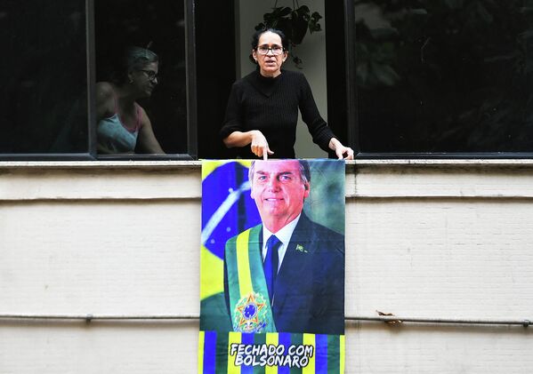 A supporter of Brazilian President Jair Bolsonaro displays a banner of the president on a balcony before a motorcade rally and military parade to mark Brazil&#x27;s 200th anniversary of independence, in Copacabana Beach in Rio de Janeiro, on September 7, 2022. - Sputnik International