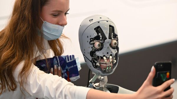 A participant of the Eastern Economic Forum in Vladivostok is photographed with the service robot-promoter Alex - Sputnik International